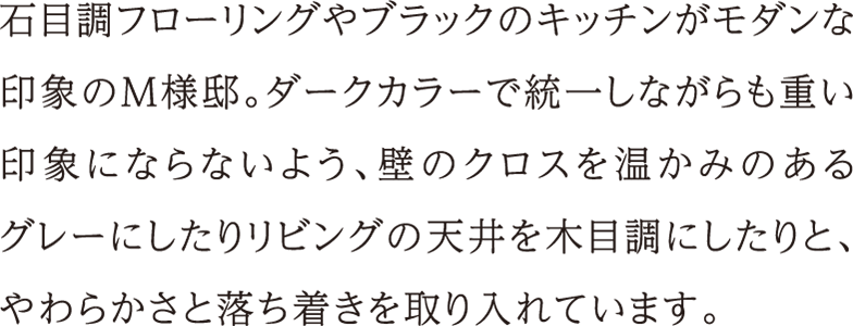 石目調フローリングやブラックのキッチンがモダンな印象のM様邸。ダークカラーで統一しながらも重い印象にならないよう、壁のクロスを温かみのあるグレーにしたりリビングの天井を木目調にしたりと、やわらかさと落ち着きを取り入れています。