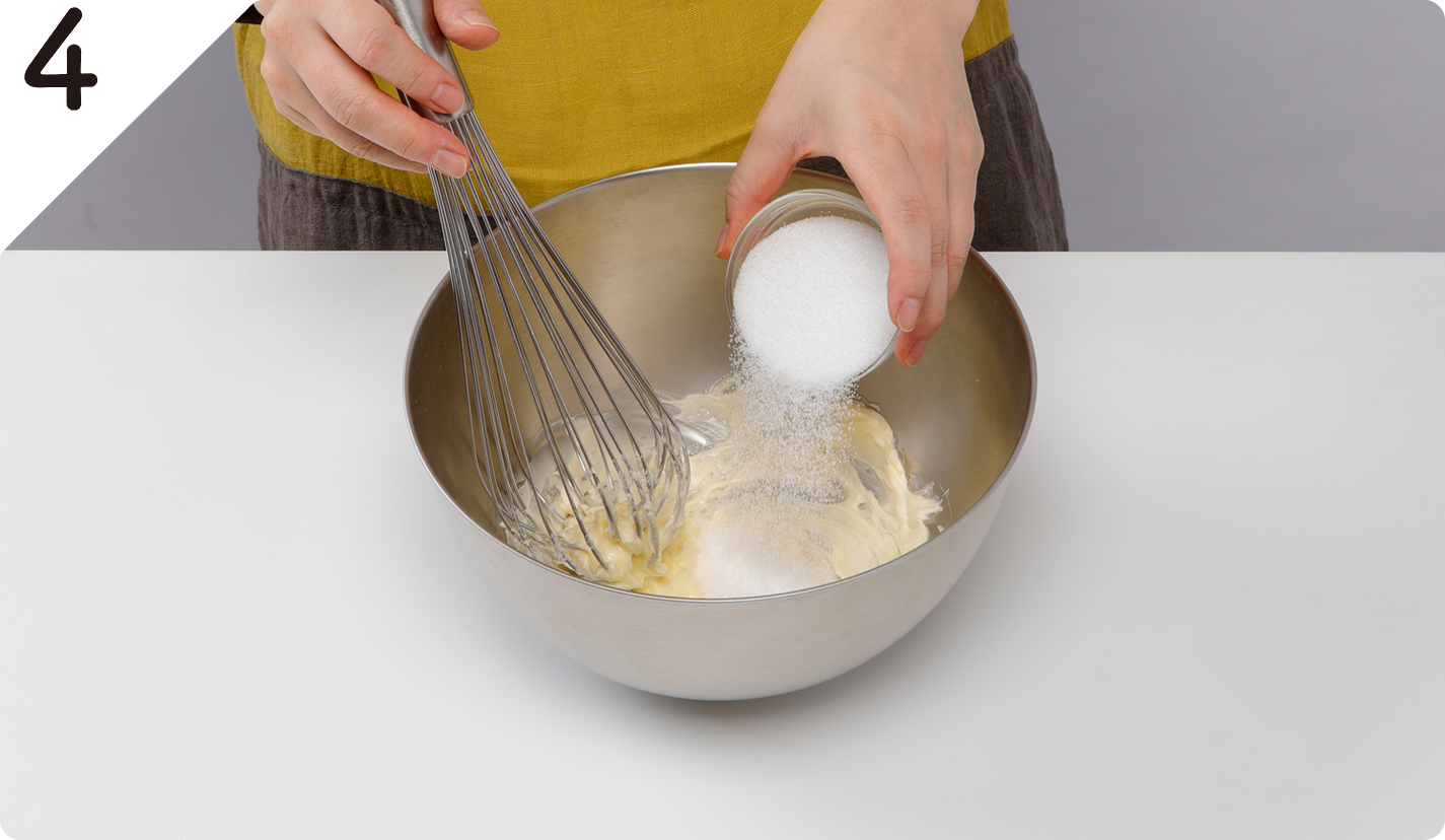 ケーキ生地をつくる。ボウルにバターを入れて泡立て器で混ぜる。グラニュー糖を加えてすり混ぜ、クリーム状にする。