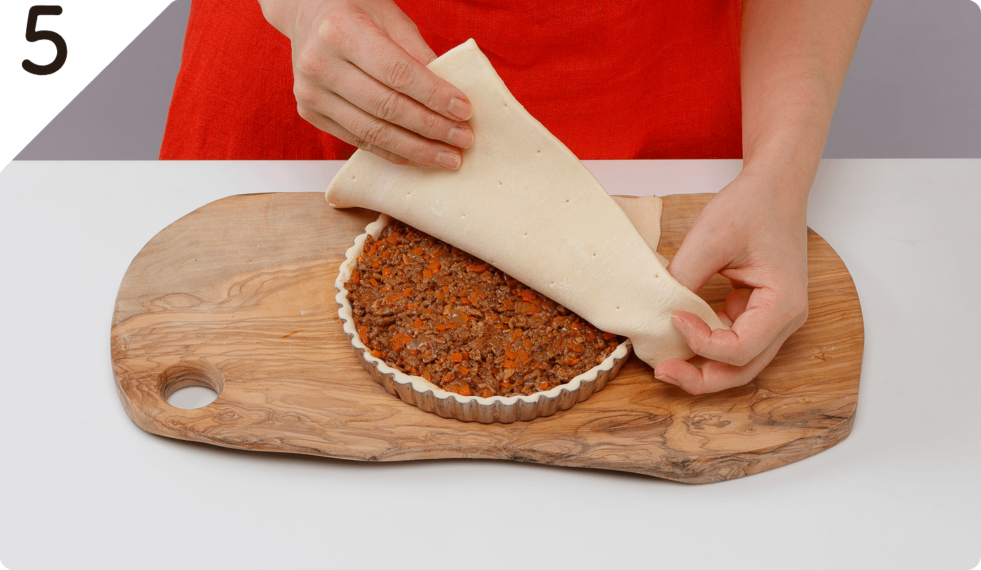 もう1枚のパイシートを上にかぶせ、余分な生地を包丁で切り落とす。