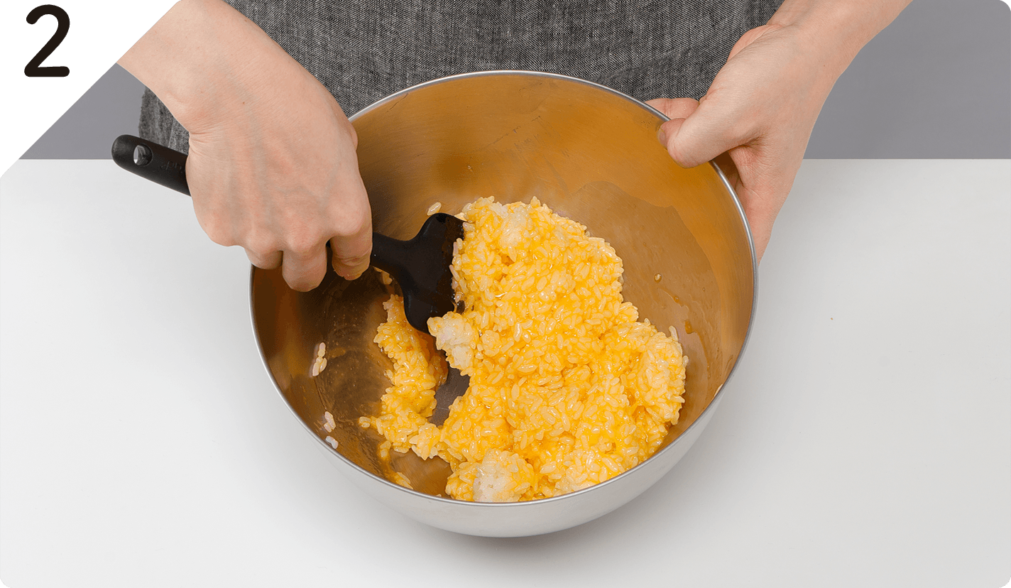 ボウルに卵、塩ひとつまみを入れて溶きほぐし、温かいご飯を加えて、ゴムベラで切るようにして混ぜながら、卵液を全体にコーティングさせる。