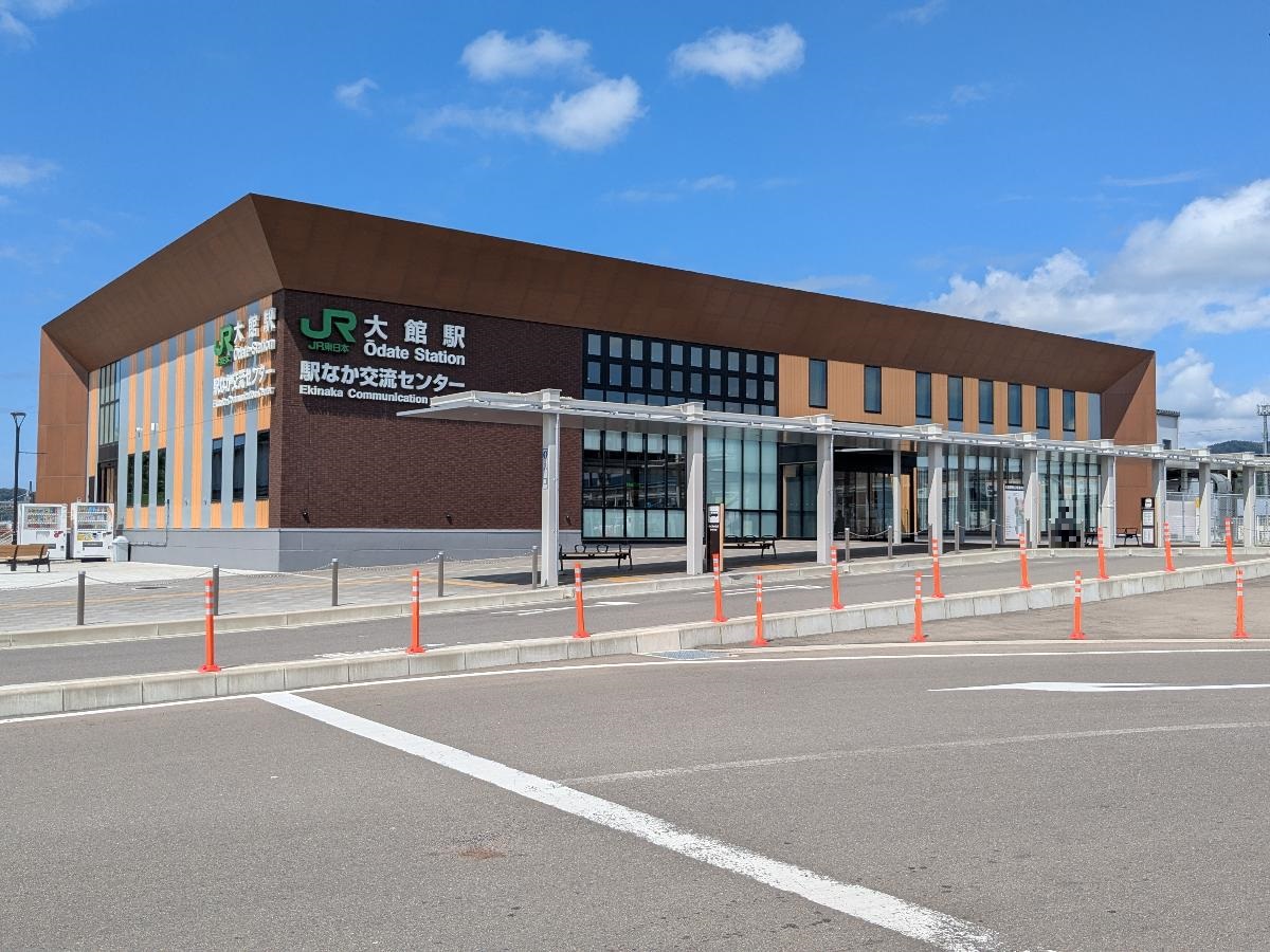 JR「大館」駅まで約1.8km（徒歩23分／車で約6分）　令和5年（2023年）10月に改築。デザインのコンセプトは「木目を基調とした地域住民がつどえる駅舎」で、各所に秋田杉や木調の仕上げを使用し、温かみのある雰囲気を演出しております。駅前には旧駅舎当時の駅前にあった「秋田犬の像」が設置しており、観光交流施設「秋田犬の里」まで駅から約160mの位置にあります。
