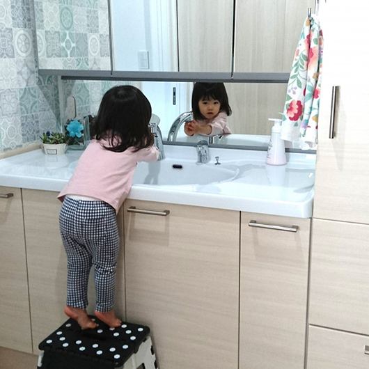 洗面台で手洗いの仕草をしている子どもの写真