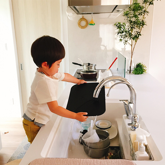 キッチンで洗い物をしている子どもの写真