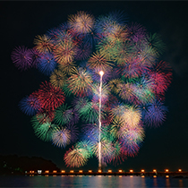 三尺玉の花火が打ち上げられて色とりどりに咲いている光景の写真