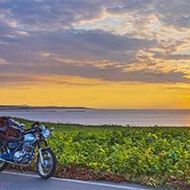 道路脇に駐車しているバイクと夕焼けの風景