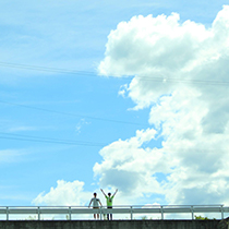 大きな夏雲とその下で小さく映っている人の写真