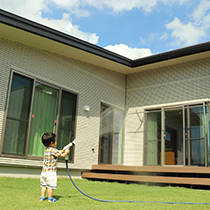 庭で水やりをしている子どもの写真