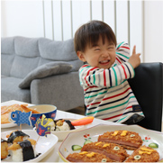 食卓の前で笑っている子どもの写真