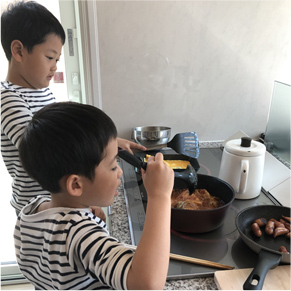 キッチンで料理している子どもたちの写真