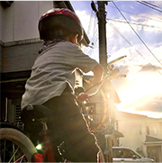 夕日に向かって自転車を漕いでいる子どもの写真