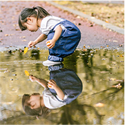 水たまりの上で遊んでいる子どもの写真