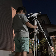 望遠鏡を覗いている子どもの写真