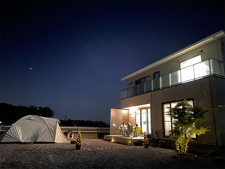 夜に家の庭でキャンプをしている家族の写真