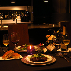 ワインやステーキが並んでいる高級レストランのような雰囲気の食卓の写真